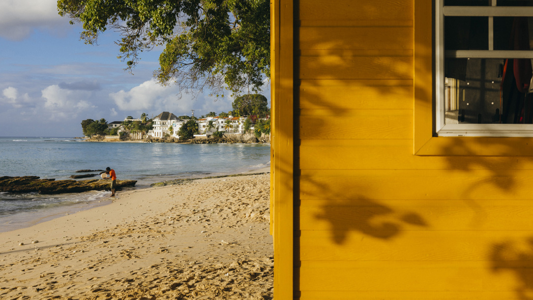 A yellow wooden structure on a beach in Barbados.