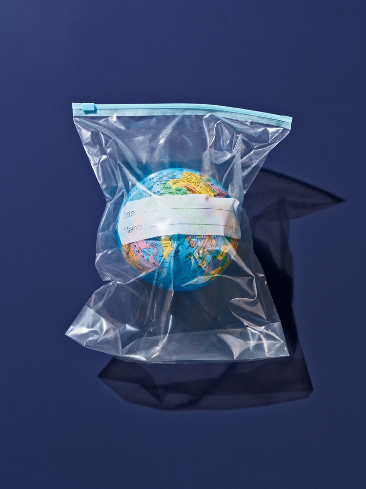 A model globe in a plastic bag against a blue background.