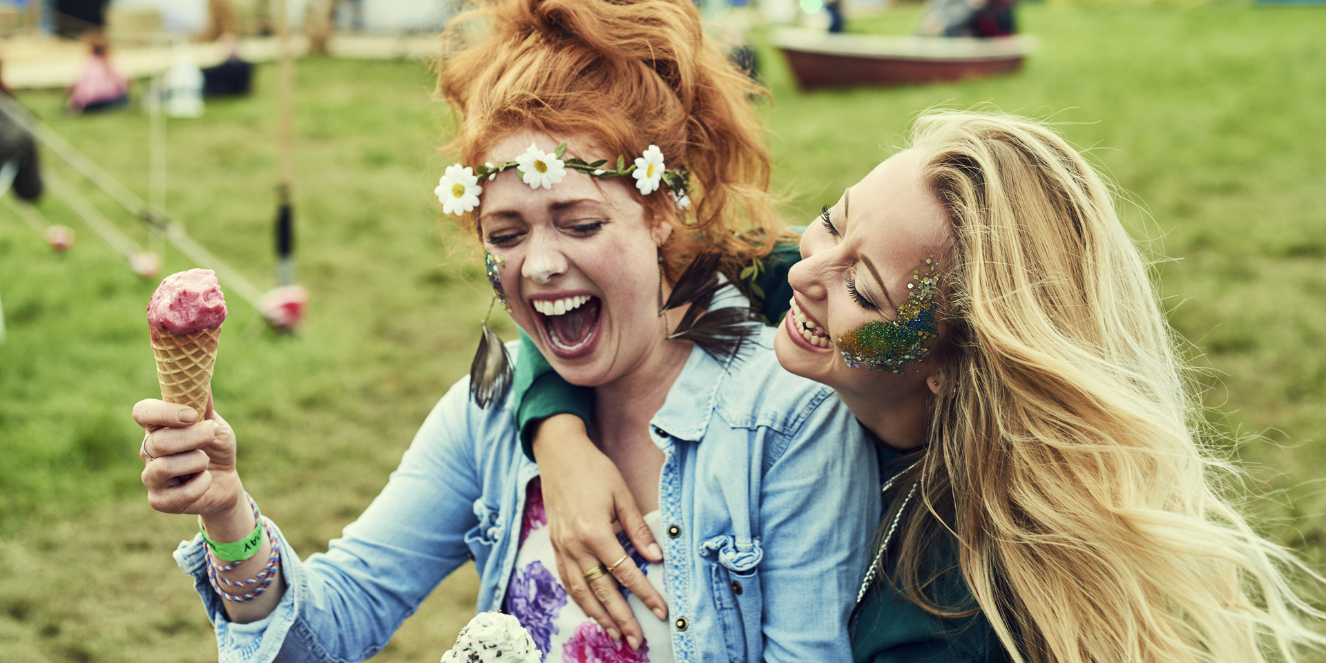 Two women eating ice cream at a music festival.