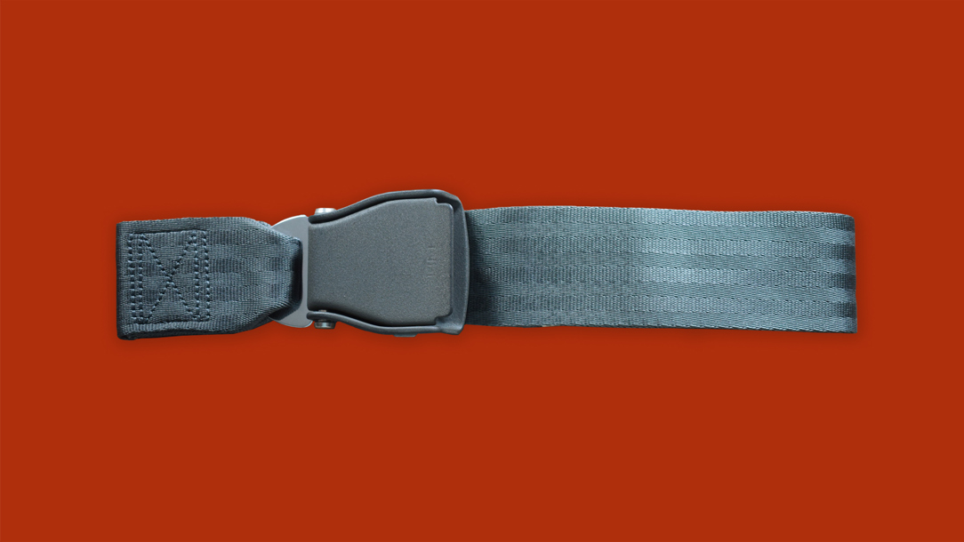 An airplane seat belt on a bright red background.