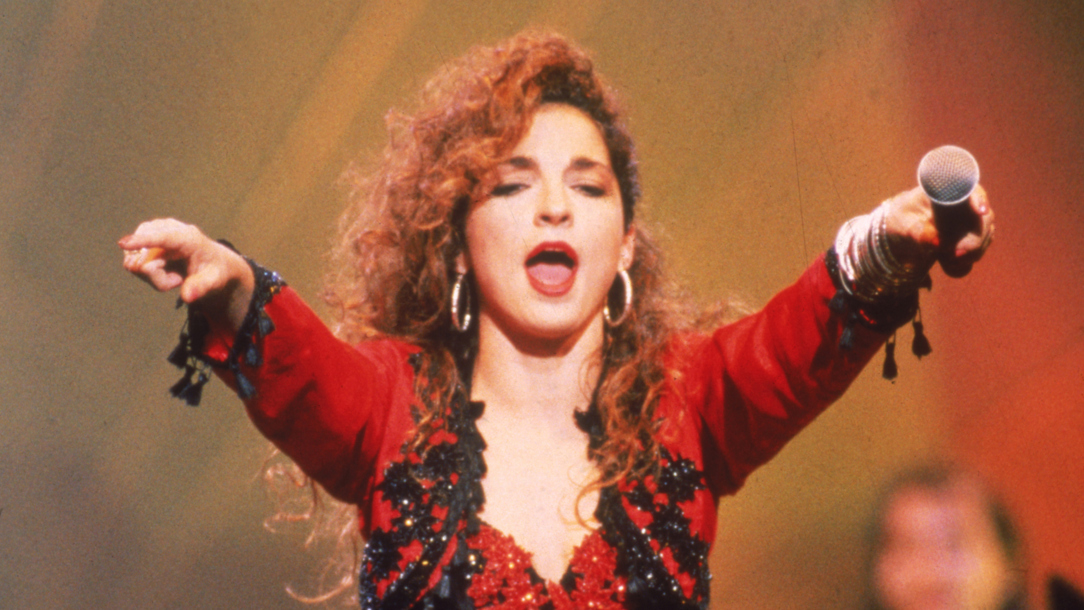 A portrait of Gloria Estefan singing.