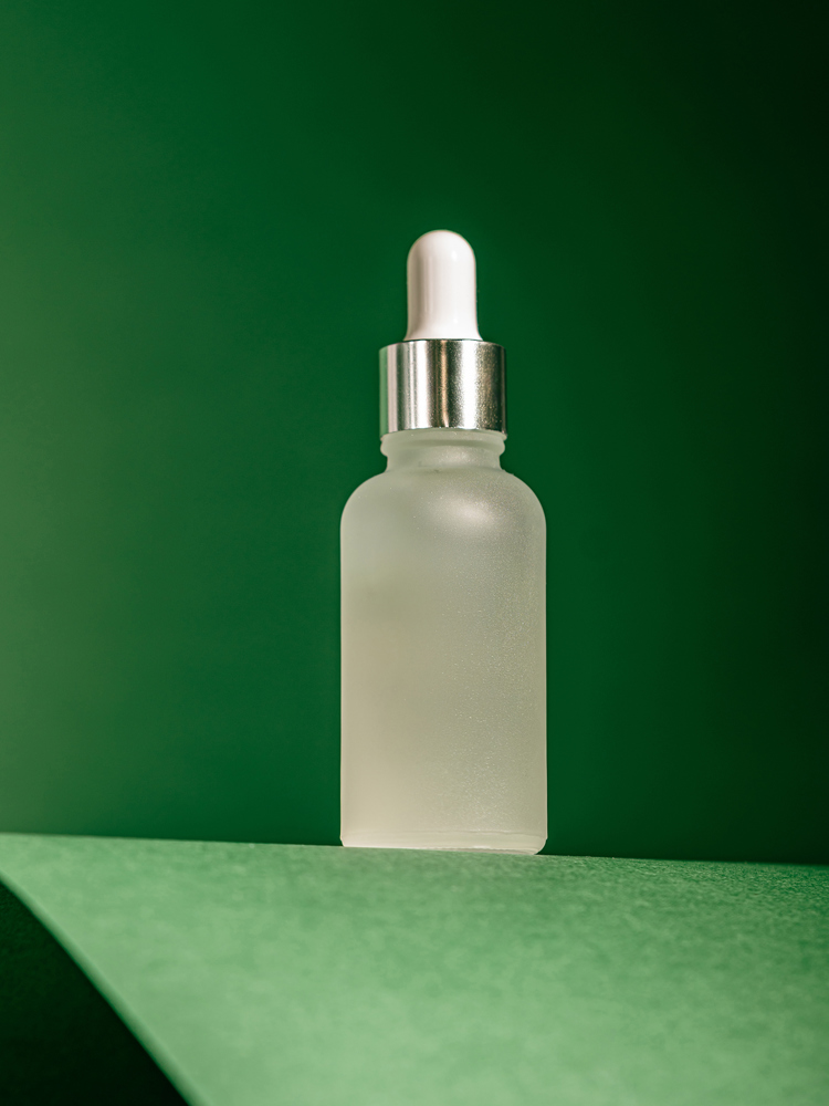 A small toiletries bottle against a green background.