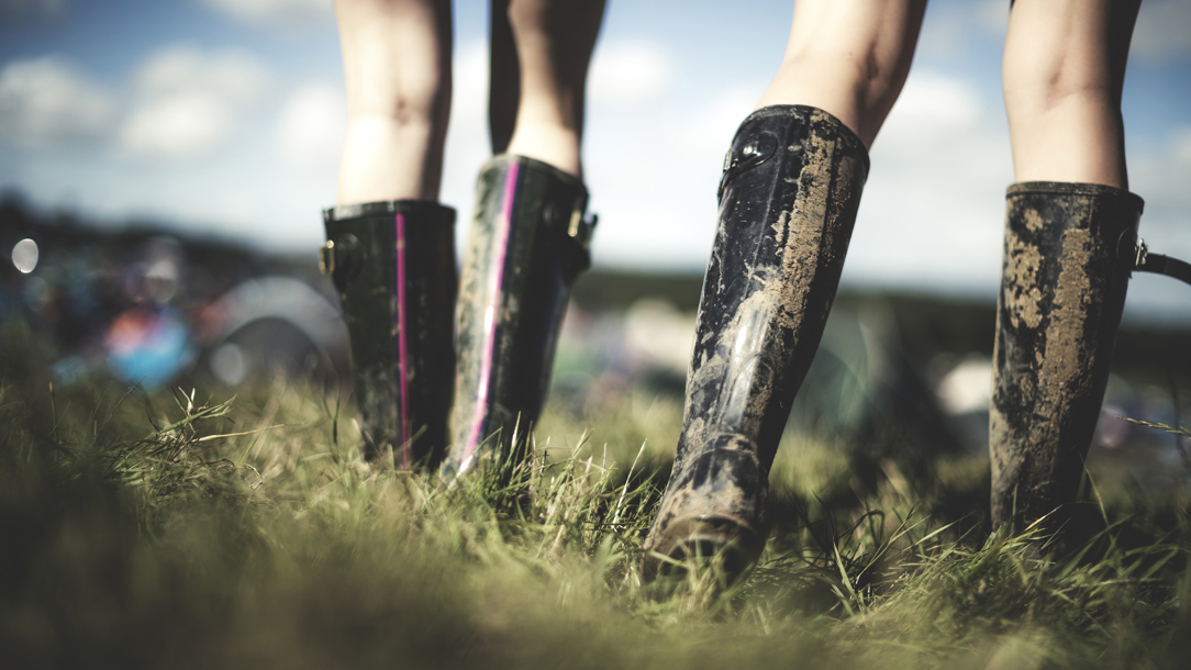 Two women wearing wellington boots in a field.
