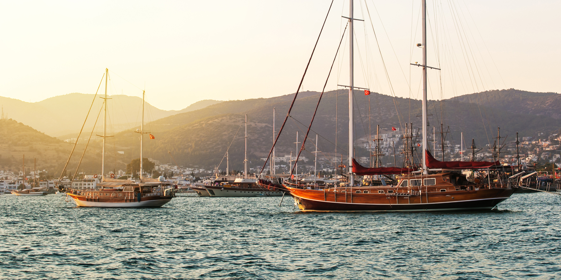 Boats on the sea in Bodrum with sunlight on the water.