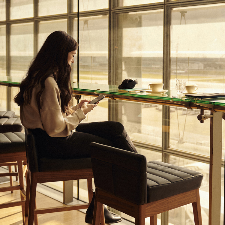 A woman enjoying the view of the airport runway in a British Airways lounge