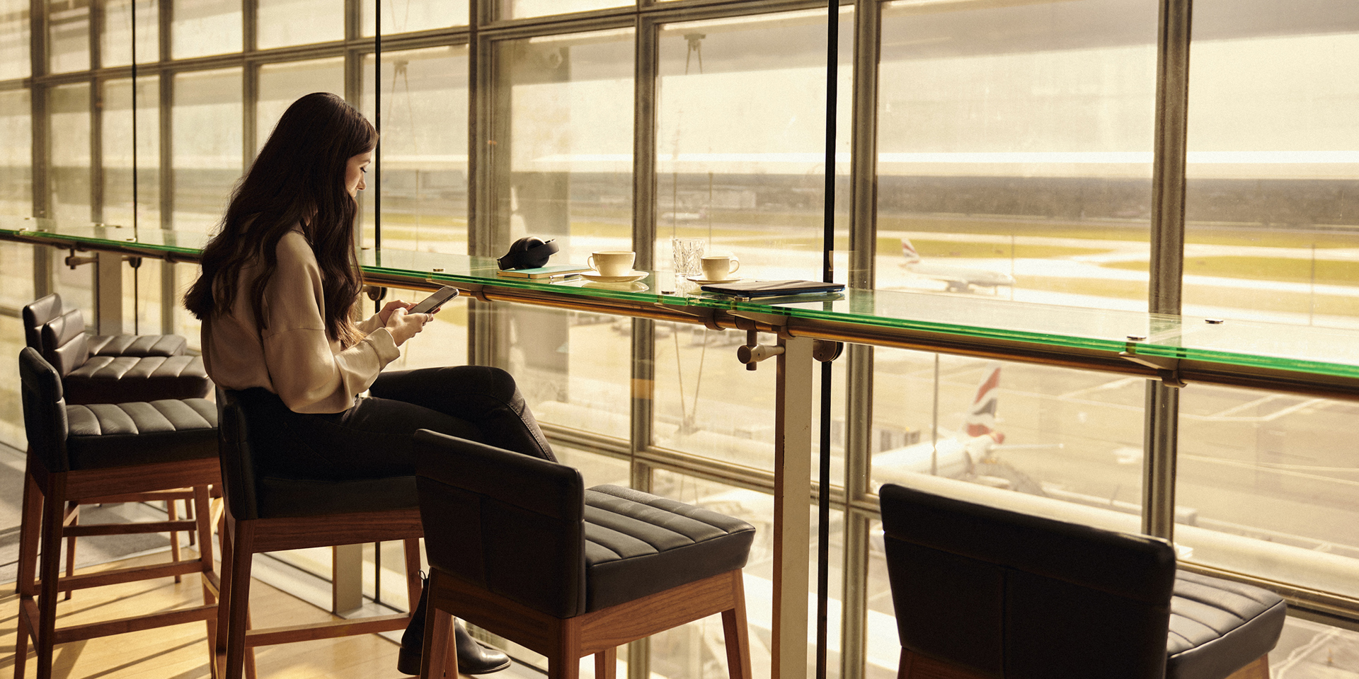 A woman enjoying the view of the airport runway in a British Airways lounge