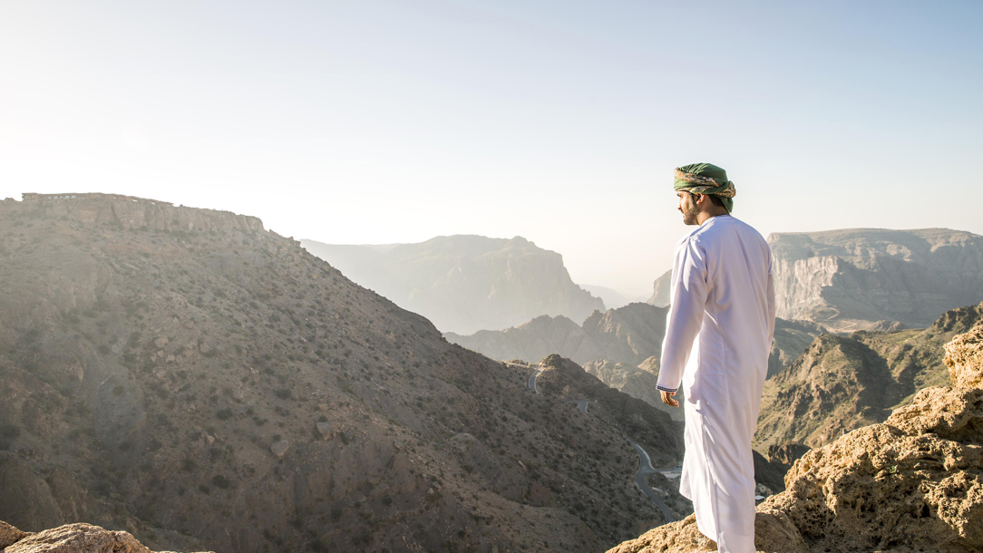 A man from the Anantara Al Jamal Al Akhdar Resort looking at the view.